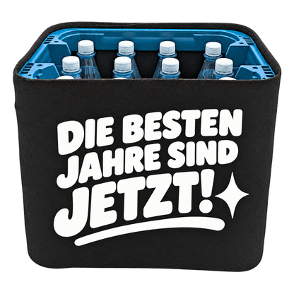 Schwarze KistenBlende für Wasserkisten mit 12 × 1 l PET-Flaschen mit weißem Geburtstagsmotiv „Die besten Jahre sind jetzt!“.