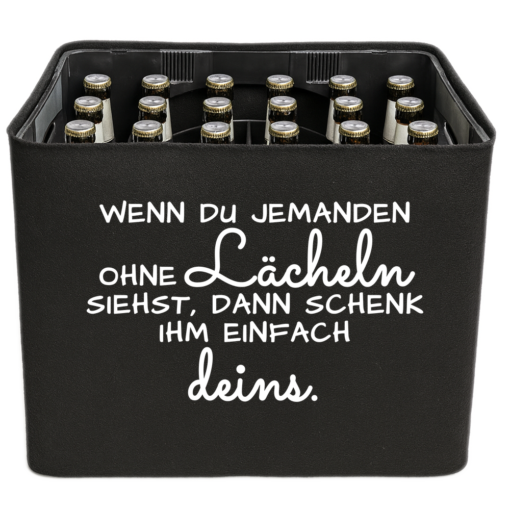 Schwarze KistenBlende mit weißem Spruch „Wenn du jemanden ohne Lächeln siehst, dann schenk ihm einfach deins.“ – Bier 24 × 0,33 l und Bier 20 × 0,5 l.