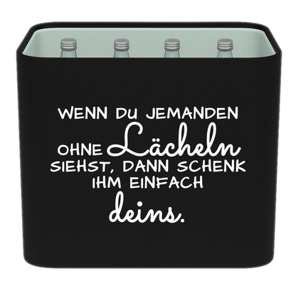 Schwarze KistenBlende mit weißem Spruch „Wenn du jemanden ohne Lächeln siehst, dann schenk ihm einfach deins.“ – Wasser Glas.