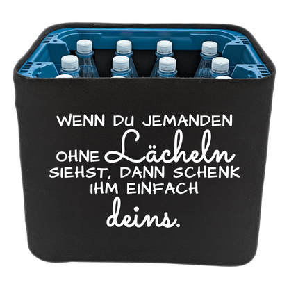 Schwarze KistenBlende mit weißem Spruch „Wenn du jemanden ohne Lächeln siehst, dann schenk ihm einfach deins.“ – Wasser PET.