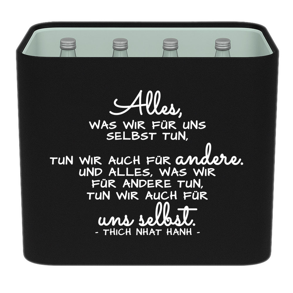 Schwarze KistenBlende mit weißem Spruch „Alles, was wir für uns selbst tun, tun wir auch für andere. Und alles, was wir für andere tun, tun wir auch für uns selbst. — Thich Nhat Hanh“ – Wasser Glas.