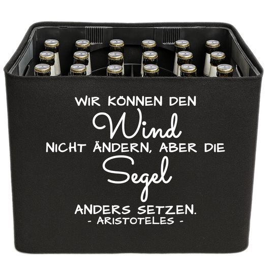 Schwarze KistenBlende mit weißem Spruch „Wir können den Wind nicht ändern, aber die Segel anders setzen. — Aristoteles“ – Bier 24 × 0,33 l und Bier 20 × 0,5 l.