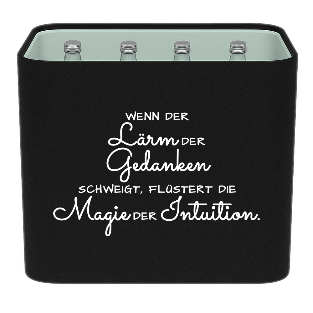 Schwarze KistenBlende mit weißem Spruch „Wenn der Lärm der Gedanken schweigt, flüstert die Magie der Intuition.“ – Wasser Glas.
